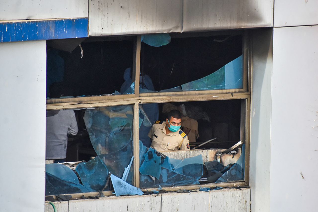 A policeman inspects a burnt-out room at the Vijay Vallabh Hospital in Virar, on the outskirts of Mumbai, after a fire broke out in the hospital's ICU, on Friday, April 23. 