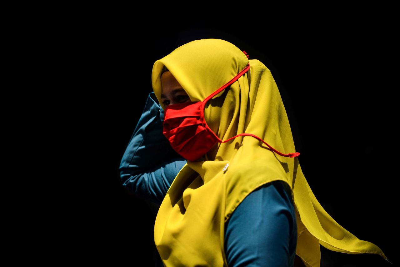 A woman wearing a face mask walks through a market in Banda Aceh, Indonesia on March 24.