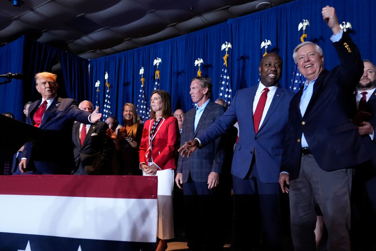 Former President Donald Trump gestures at Senators Tim Scott and Lindsey Graham at a primary election night party at the South Carolina State Fairgrounds in Columbia, South Carolina, on February 24. 