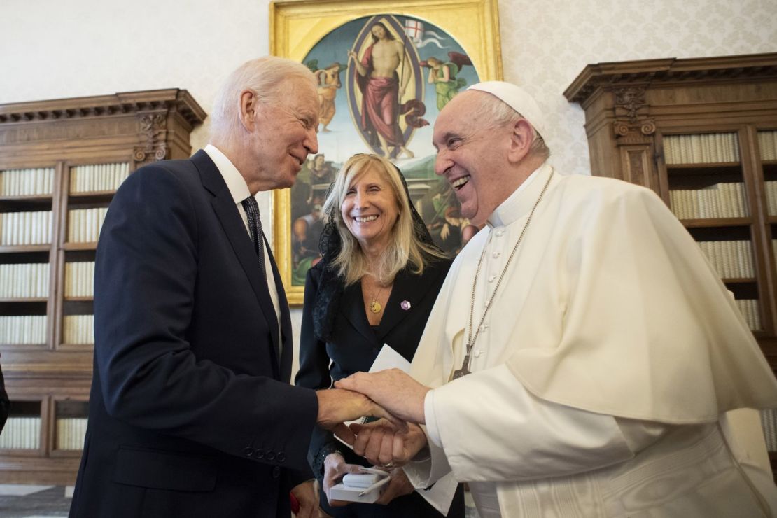 El presidente de Estados Unidos, Joe Biden, le entrega al papa una moneda conmemorativa durante su viaje al Vaticano en octubre de 2021. La moneda incluye la insignia de una unidad de la Guardia Nacional del Ejército de Delaware en la que sirvió Beau, el hijo de Biden. Biden declaró durante su visita que las monedas se entregan a "guerreros y líderes" y que el papa es "el guerrero por la paz más importante" que conoció.