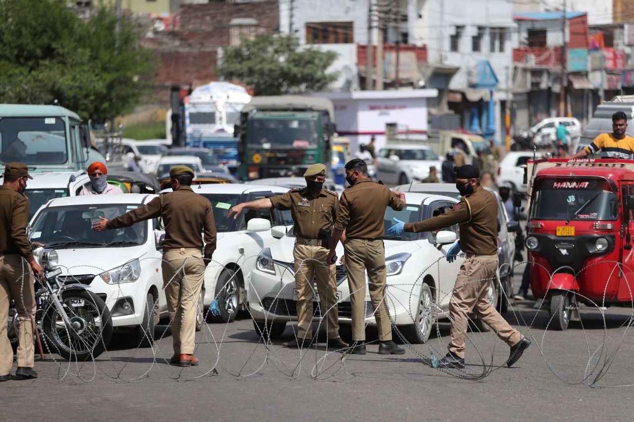 Policemen erect barbed wire to stop commuters as they enforce a lockdown in Jammu, India on March 23.