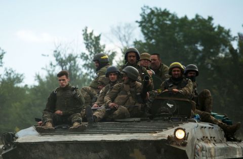 Ukrainian soldiers ride on an armored personnel carrier (APC) on a road out of the eastern Luhansk region, Ukraine, on June 23.