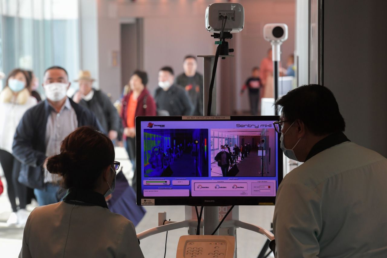 Health officers screen arriving passengers from China with thermal scanners at Changi International Airport in Singapore.