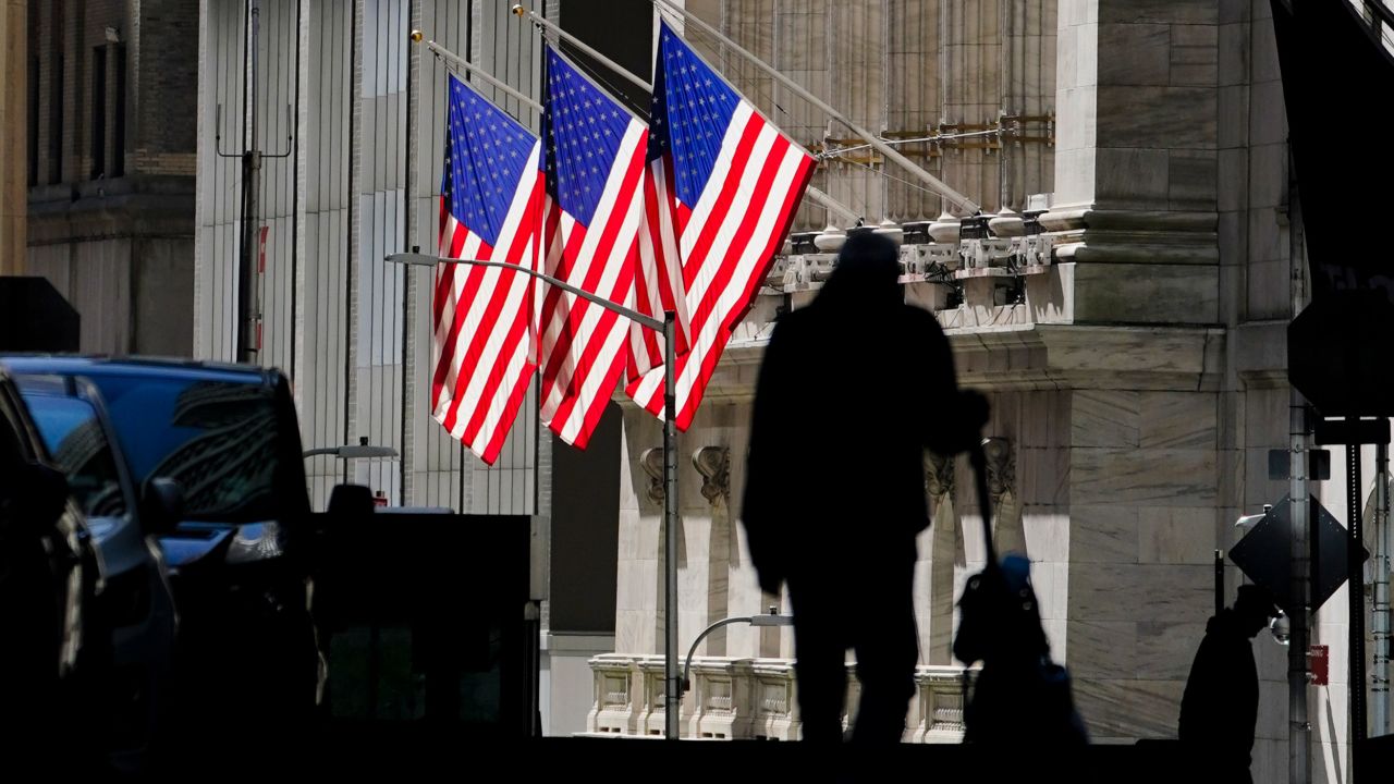 A pedestrian walks past the New York Stock Exchange on October 14.