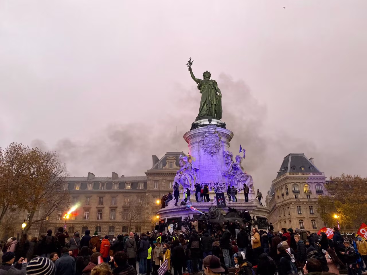 Protestors gather around a statue at Place de la République which represents Marianne, a fictional woman who represents the French Republic since the revolution.
