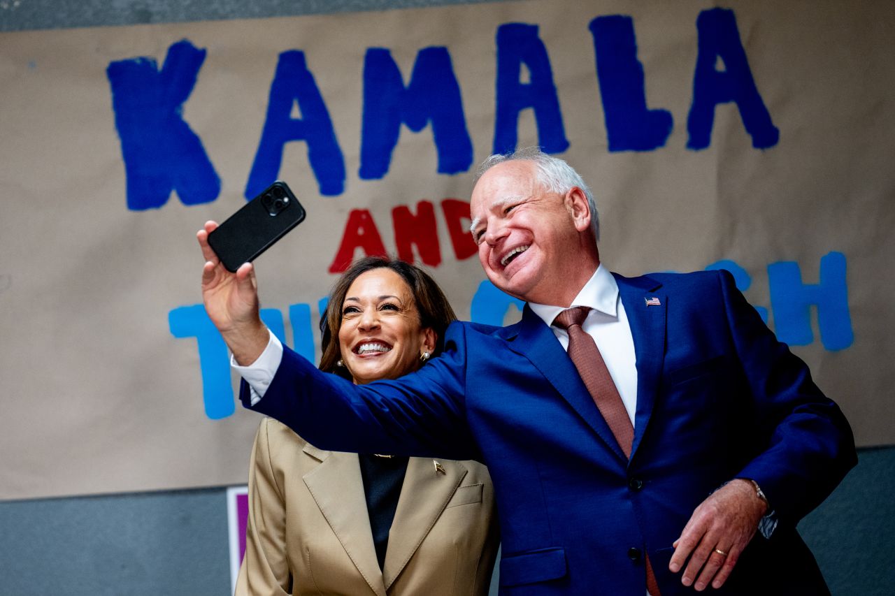 Kamala Harris and Tim Walz take a selfie in front of a sign that reads "Kamala and The Coach" during a stop at a campaign office in Glendale, Arizona, on August 9.