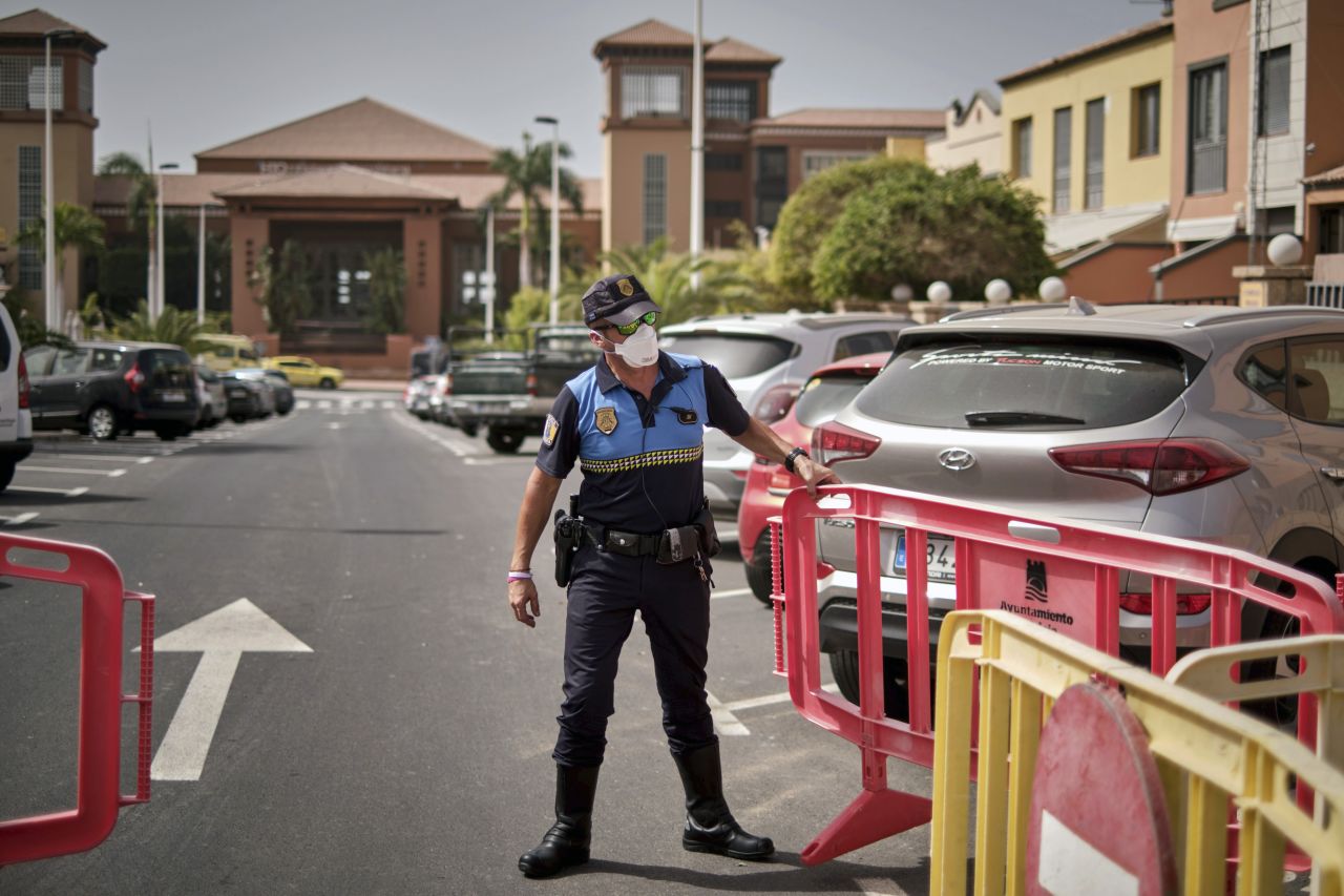 A Spanish police officer sets up a barrier blocking the access to the H10 Costa Adeje Palace hotel in Tenerife, Canary Island, Spain, on Tuesday, February 25.