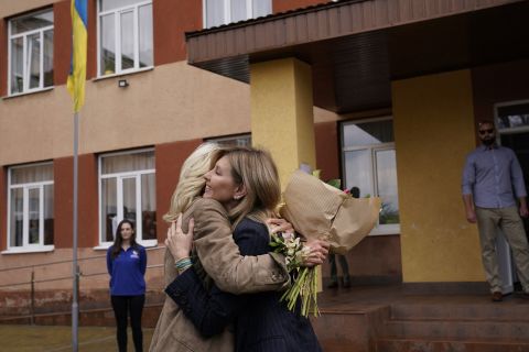 US First Lady Jill Biden, left, offers flowers to Ukraine's First Lady, Olena Zelenska, outside of School 6, a public school that has taken in displaced students in Uzhhorod, on Sunday, May 8.