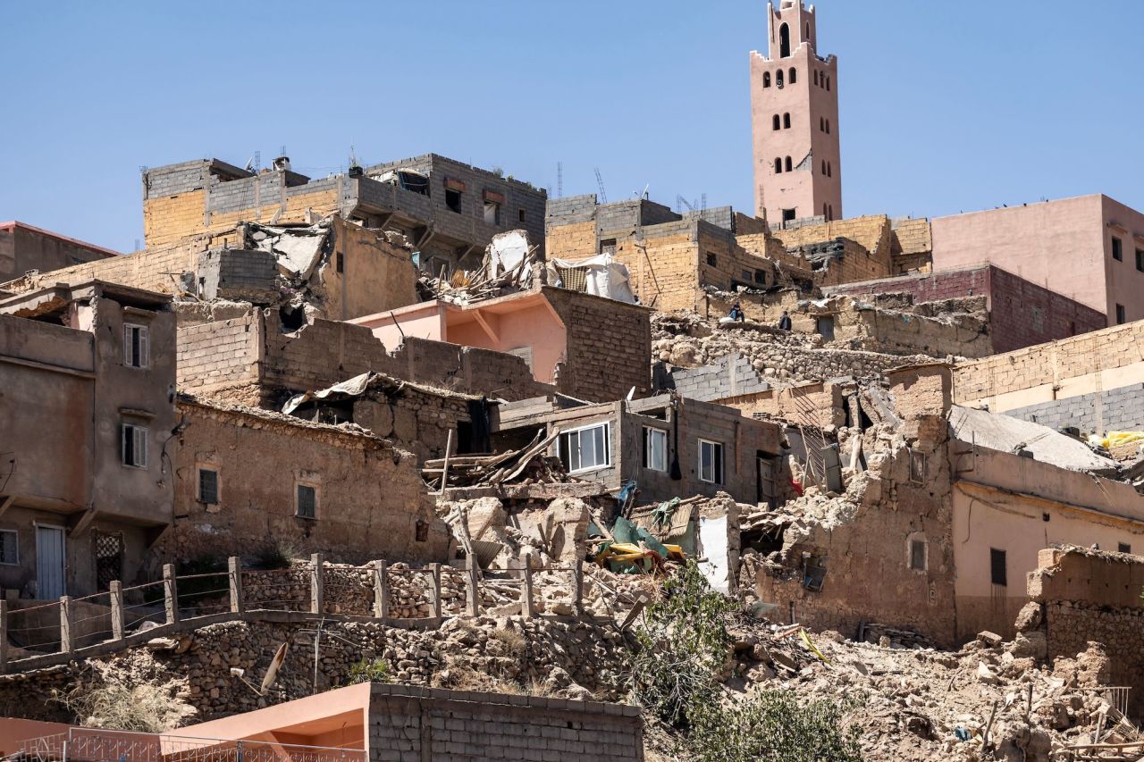 The minaret of a mosque stands behind damaged houses in Moulay Brahim on Saturday.