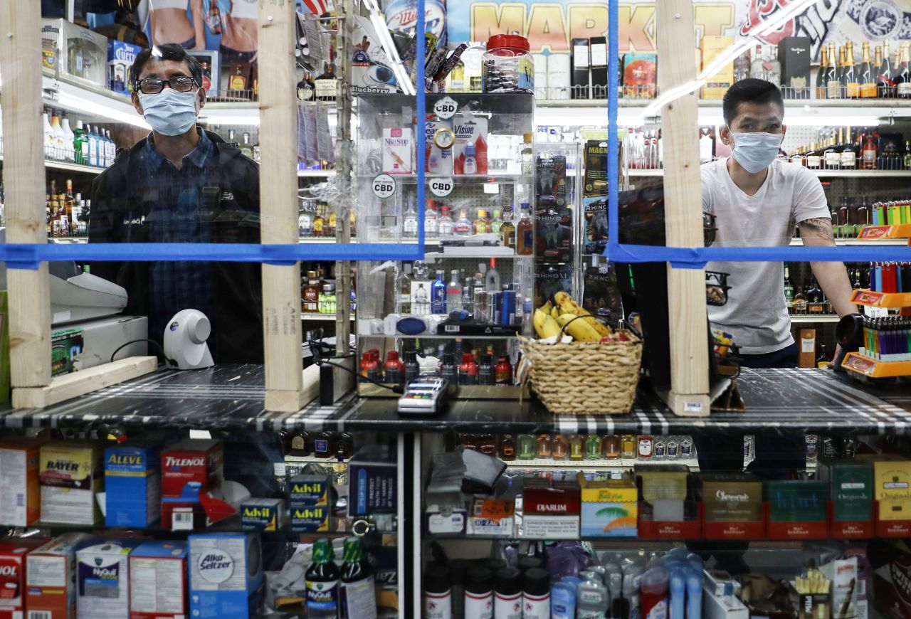 Cashiers wear face masks at a convenience store in Los Angeles, California on April 4.