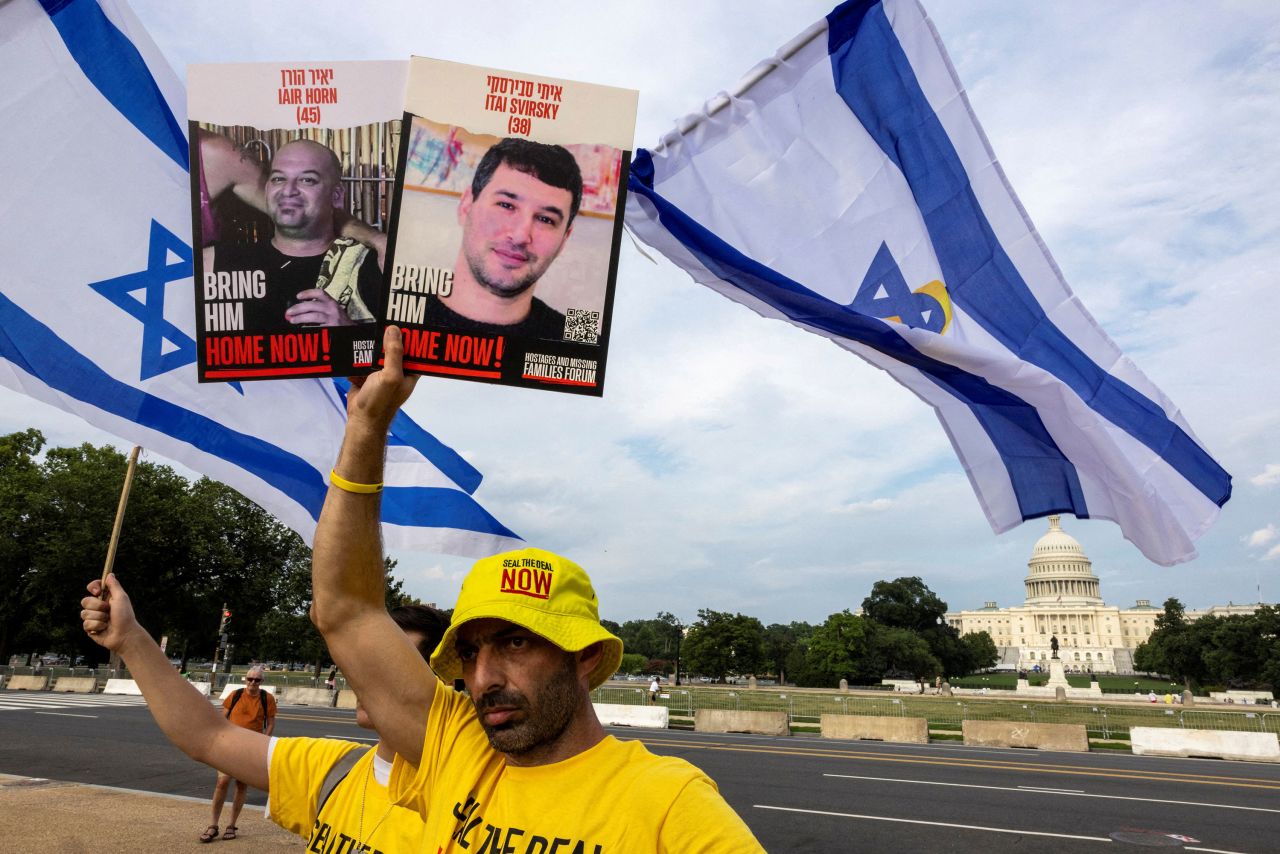 Families of Israeli hostages hold Israel's national flags and portraits of hostages as they gather at the National Mall in Washington, DC, on Wednesday.