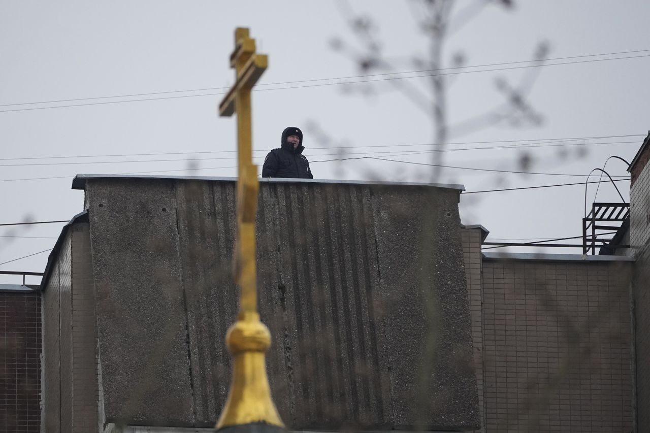 A Police officer guards on a roof of an apartment building near the Church of the Icon of the Mother of God Soothe My Sorrows, in Moscow, Russia, on March 1.