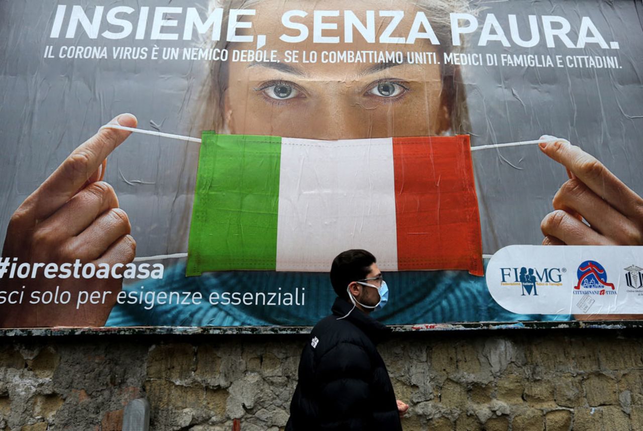 A man walks past a billboard raising awareness to the coronavirus measures?implemented by the Italian government in Naples on March 22.