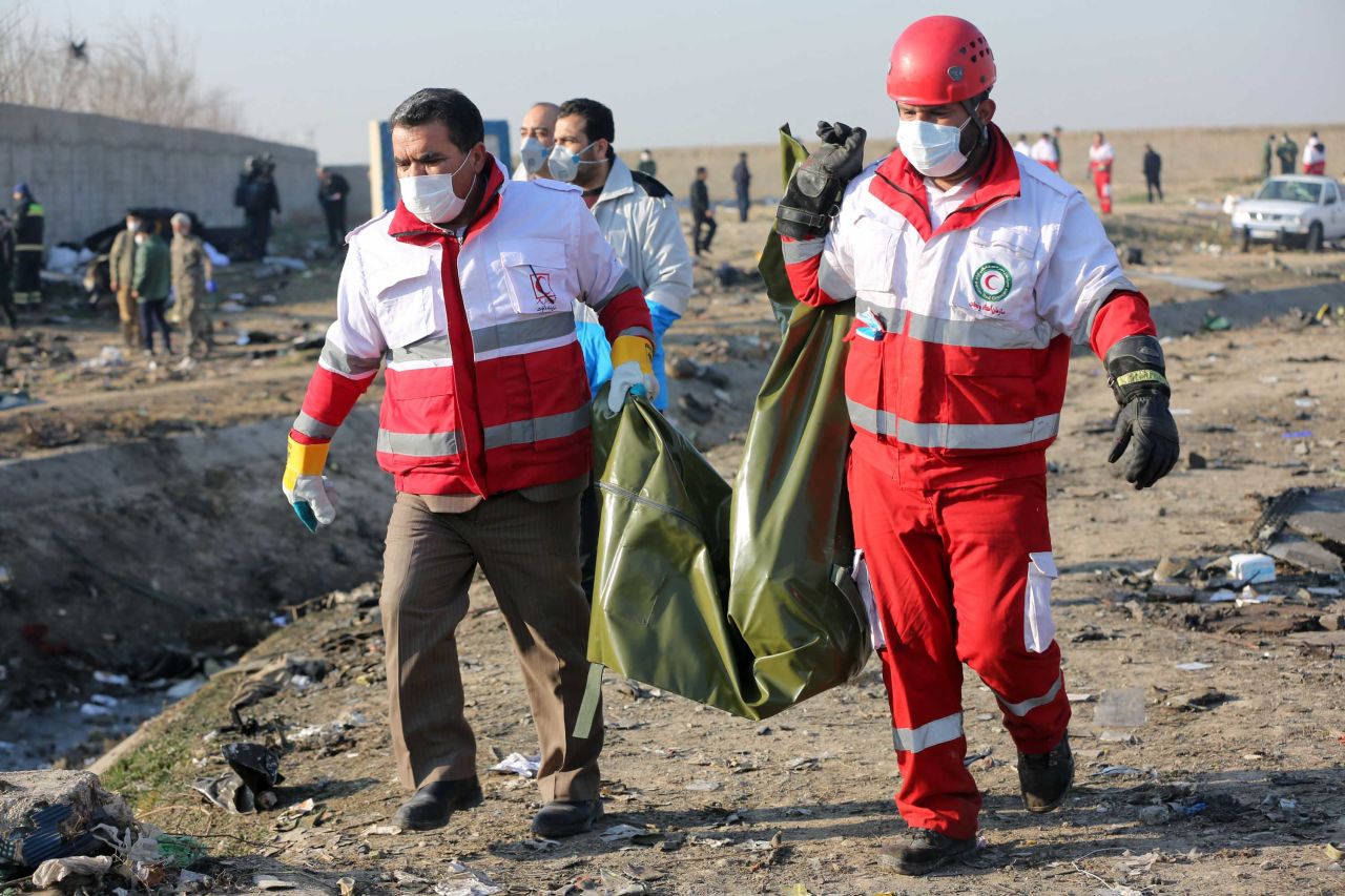 Members of the emergency services carry a victim from the scene of the crash.