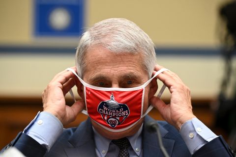 Anthony Fauci, director of the National Institute of Allergy and Infectious Diseases, removes his Washington Nationals protective mask during a House Select Subcommittee on the Coronavirus Crisis hearing on July 31. 