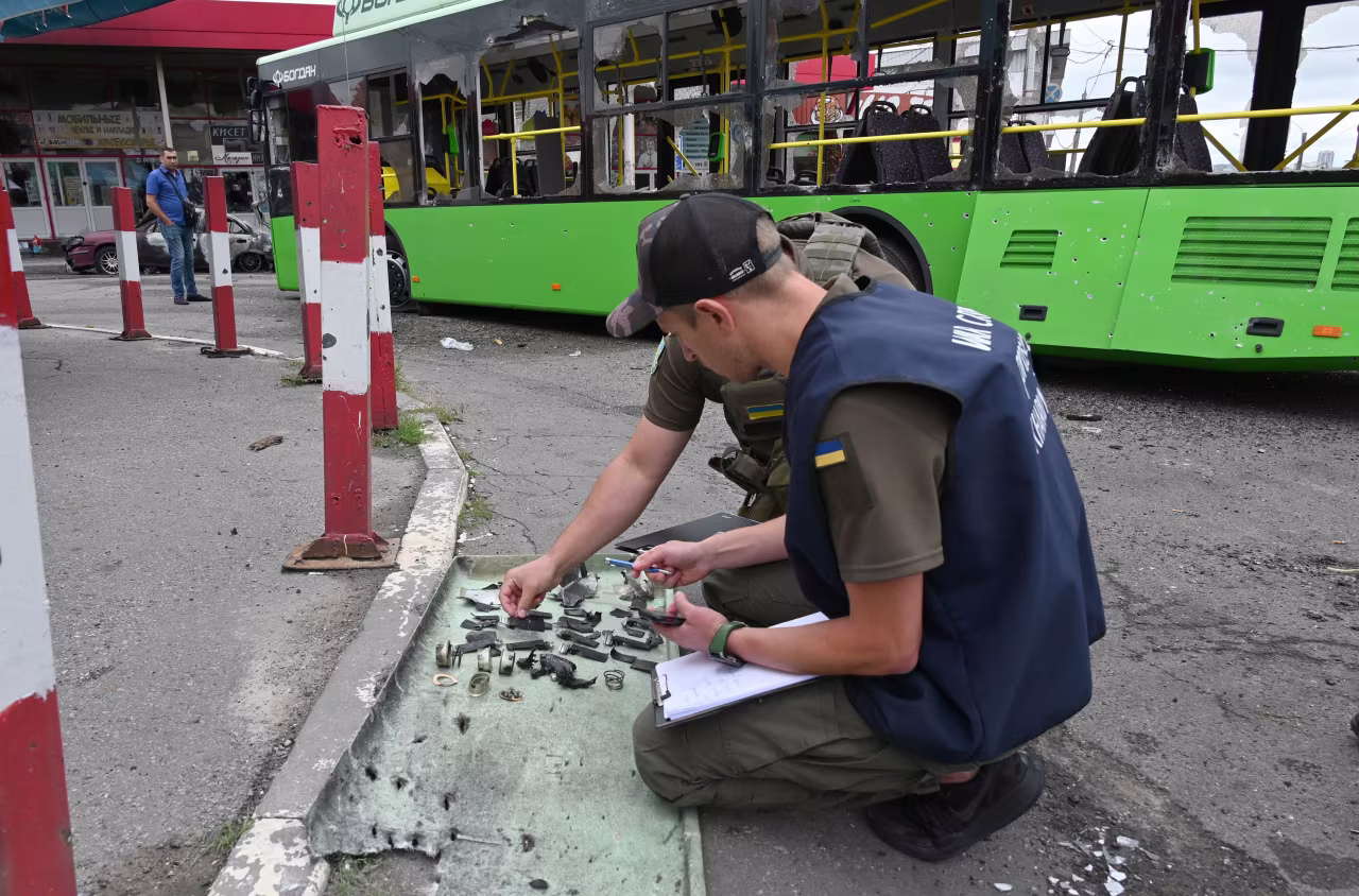 Ukrainian authorities collect fragments after a Russian rocket strike in Kharkiv, Ukraine, on Thursday.