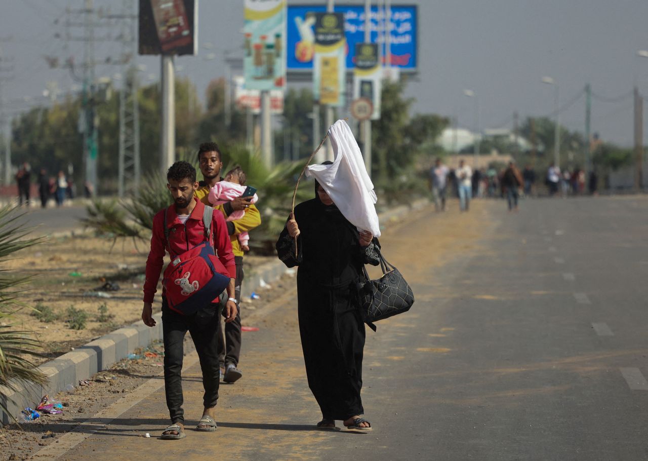 A Palestinian woman holds a white flag while evacuating with a group of civilians from the north of Gaza towards the southern region.