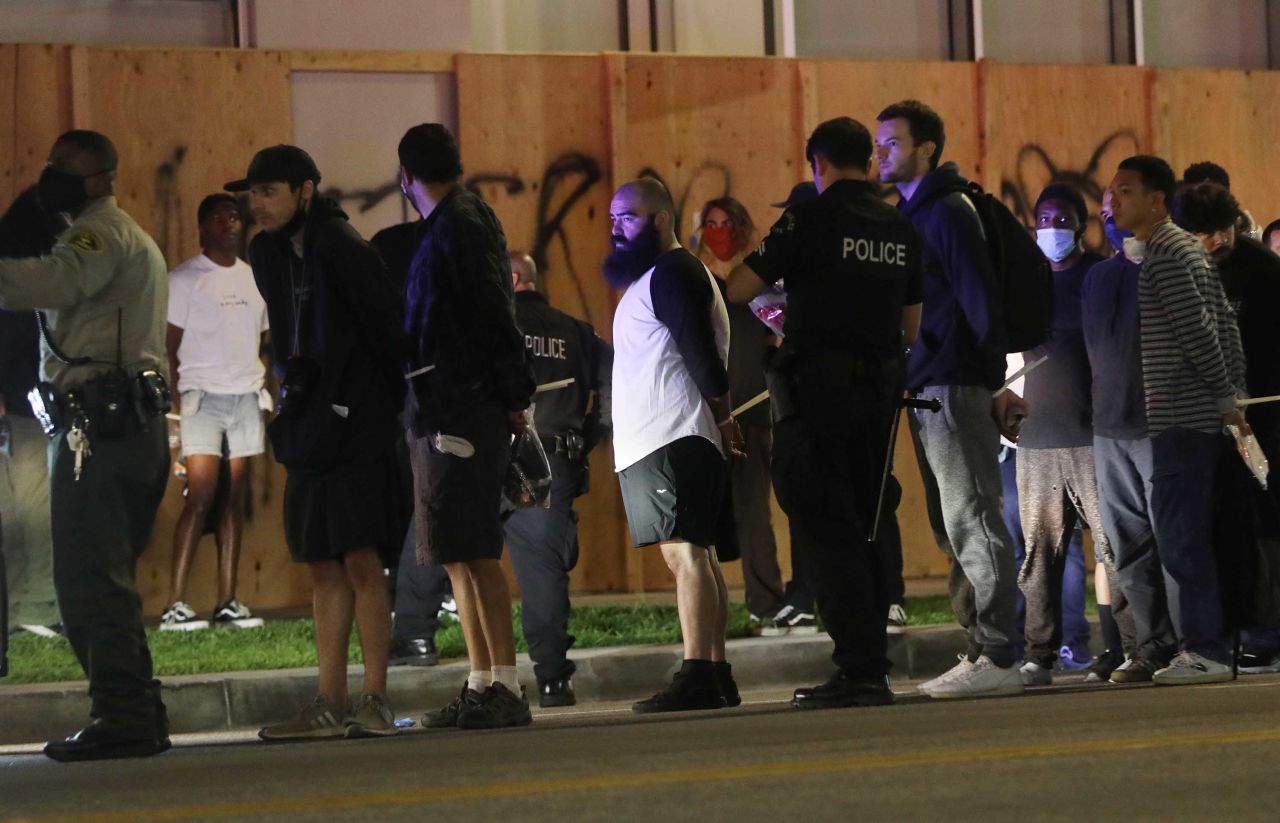 People stand handcuffed by police in the Hollywood area during an emergency curfew on June 1 in Los Angeles, California.