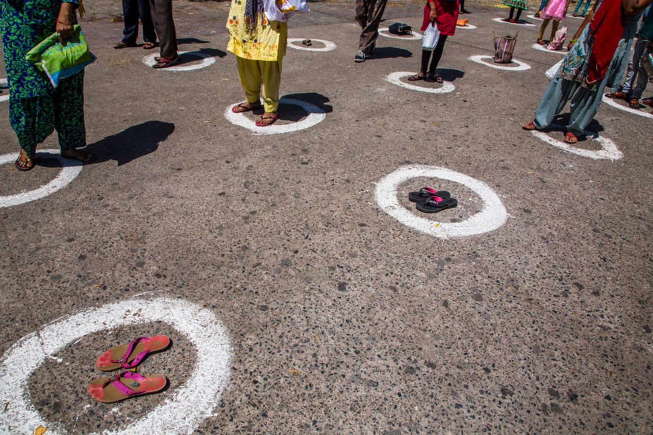 Homeless people and stranded migrant workers stand in circles marked on the ground to maintain social distance as they wait for free food in New Delhi during India's nationwide lockdown, on April 2.