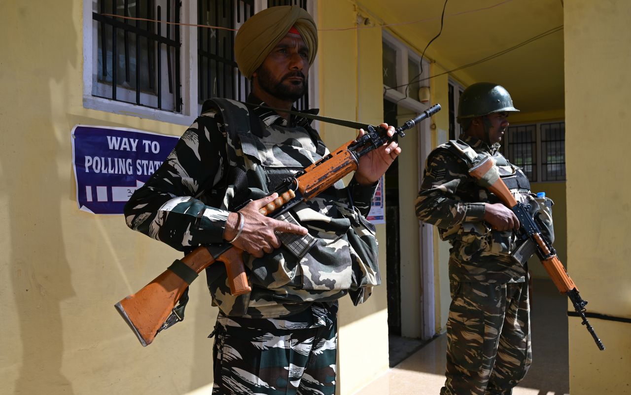 Indian paramilitary troopers stand guard at a polling station in Shopian district in Jammu and Kashmir on May 6, 2019. 