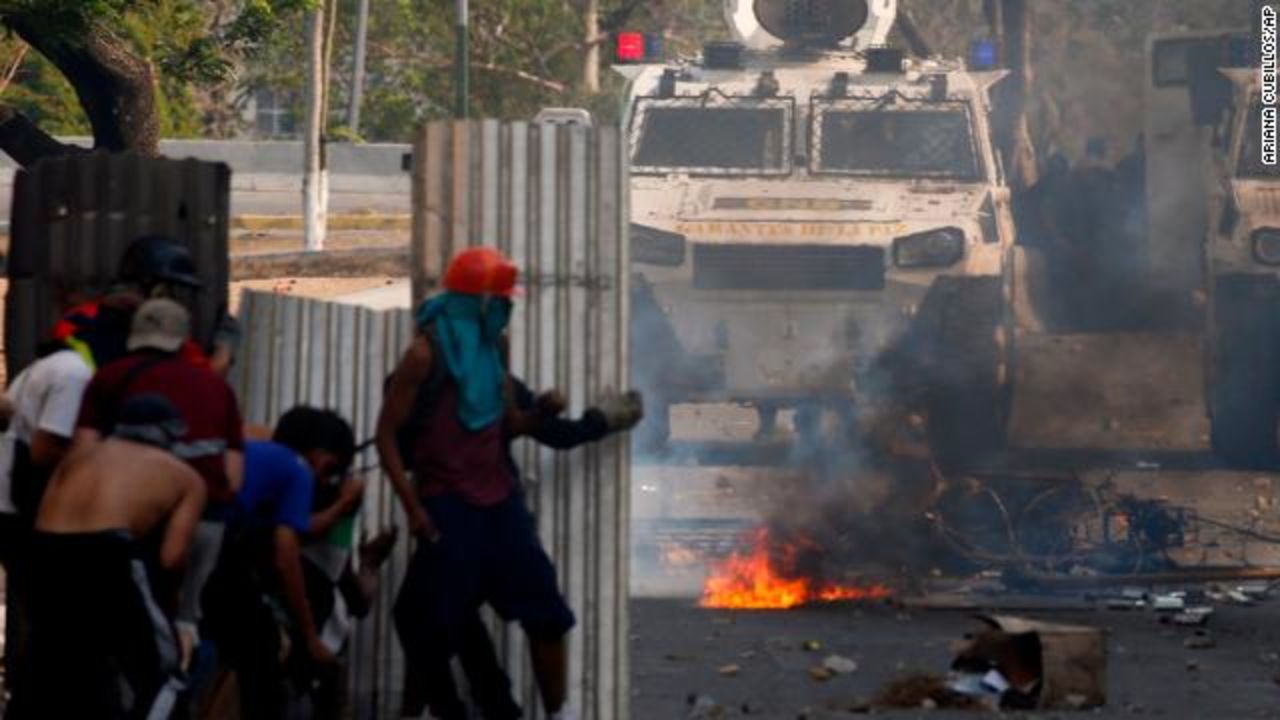 Protesters stand off with guards in Caracas Tuesday.