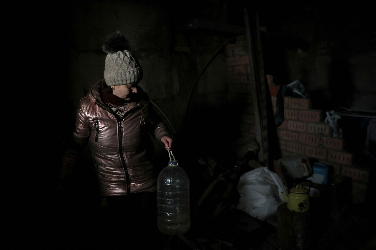 Lilia, 44, pours water into a pot to boil in the basement of an apartment building where she is currently living without?power, water or heat in Siversk,?Ukraine, on December 4.
