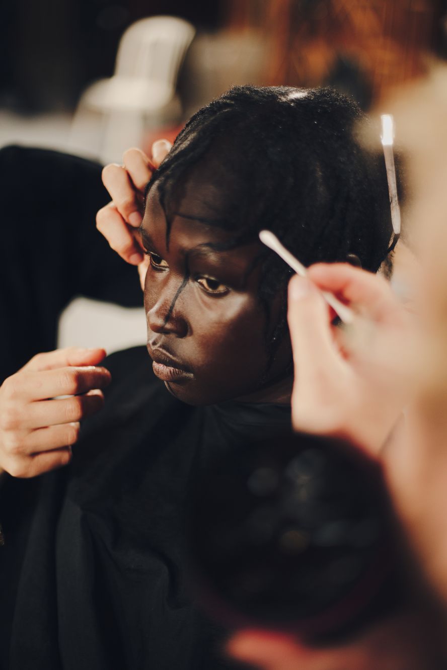 Models getting ready backstage at Yohji Yamamoto.