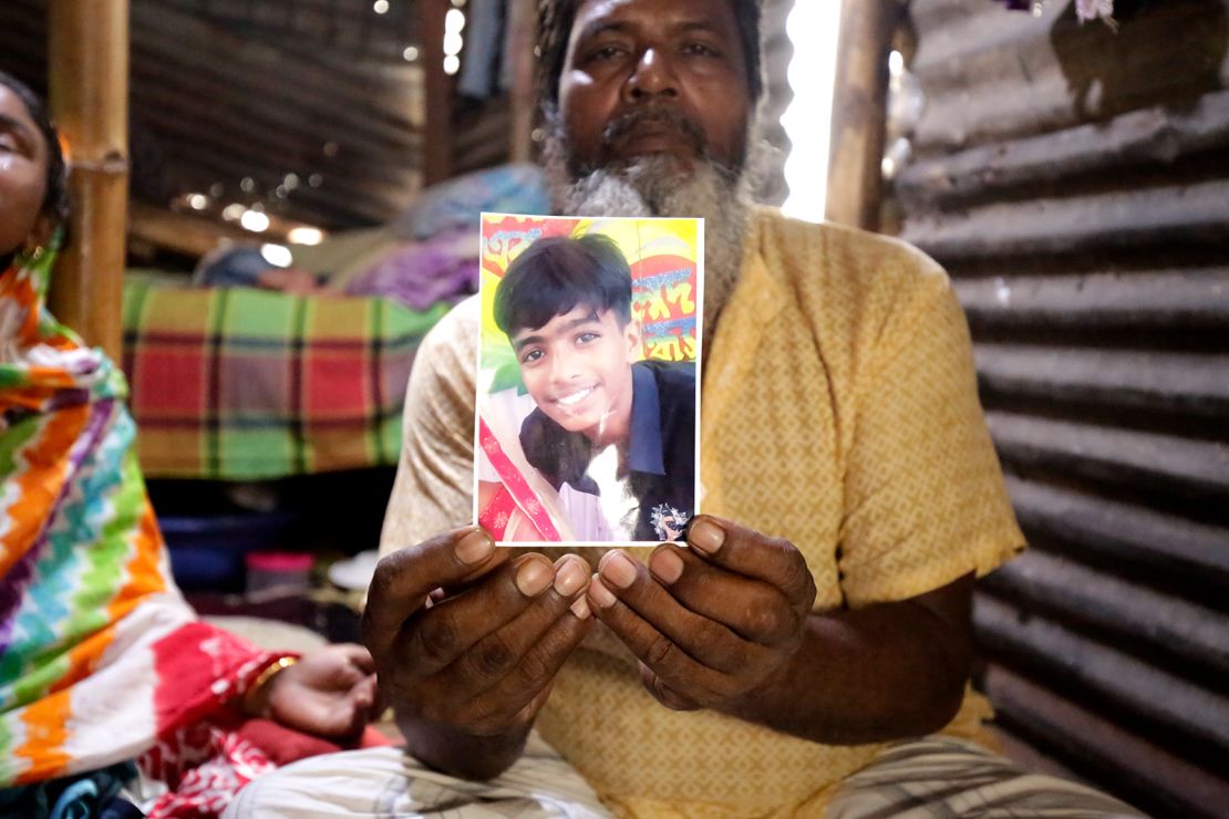 Mohammad Ramzan Ali holds a photo of his 13-year-old son Mubarak, who was killed during anti-government protests in Bangladesh.