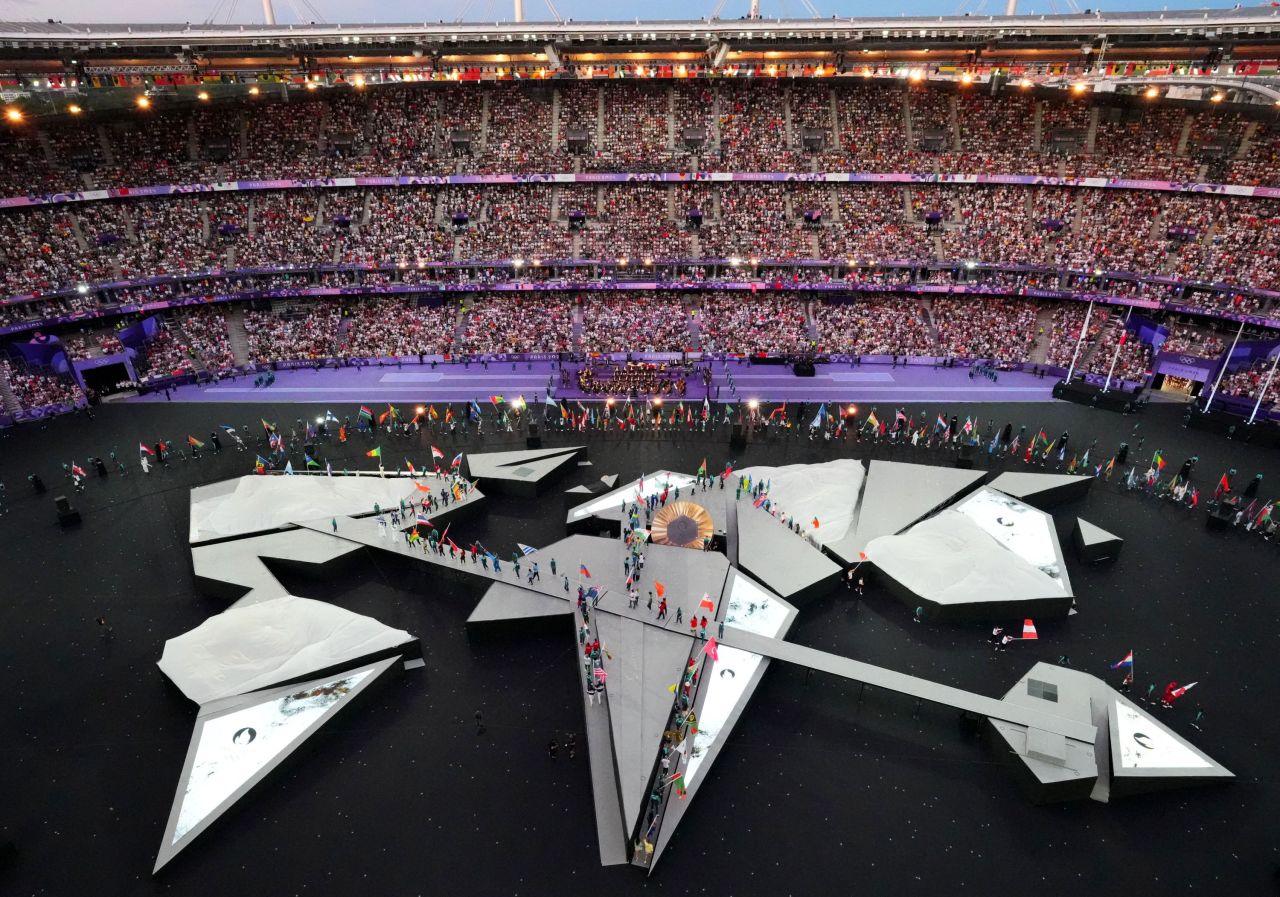 Flagbearers from every country enter the Stade de France and walk onto the stage at the start of the ceremony. 