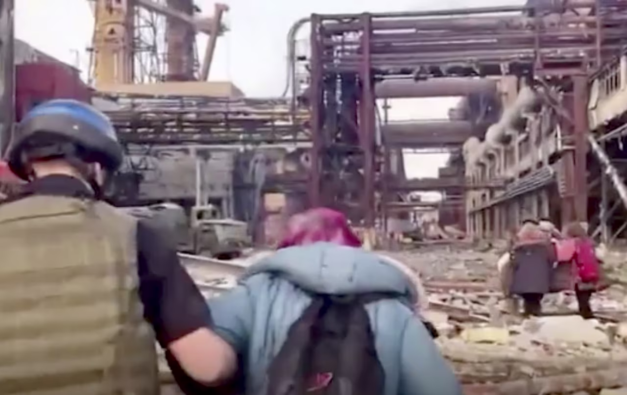 People walk over debris at the Azovstal steel plant during the evacuation.