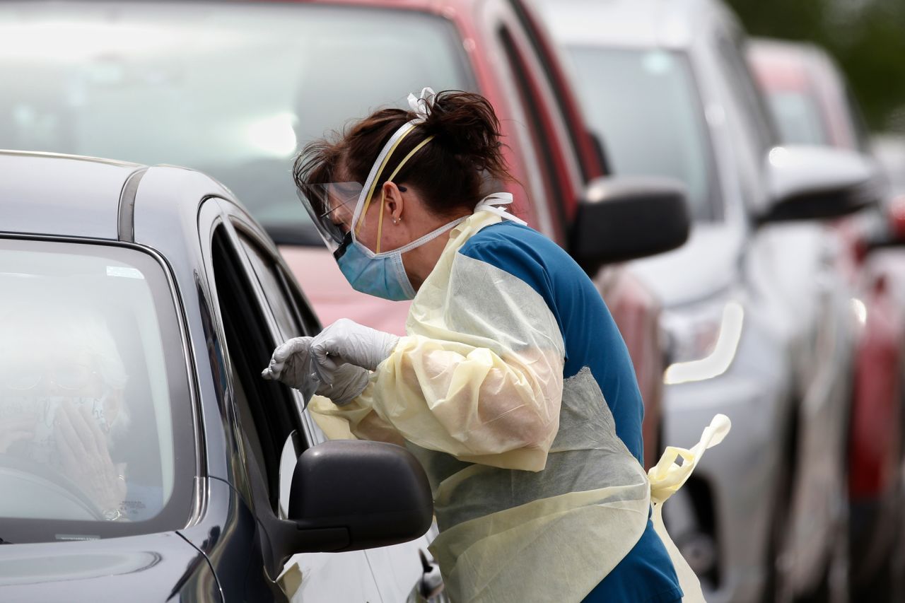 A Cleveland County Health Department employee speaks to a driver of a car at a mobile testing site for COVID-19 in Norman, Oklahoma on April 9.