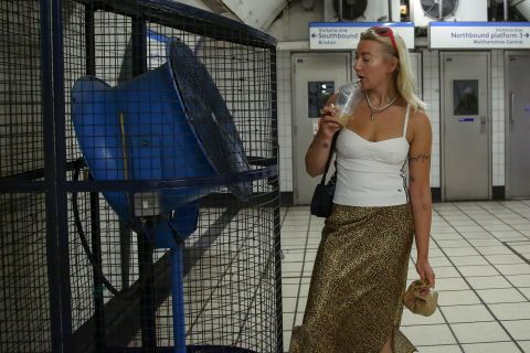 A woman cools off in front of a large fan in Kings Cross tube station during the heatwave in London, England, on July 19.
