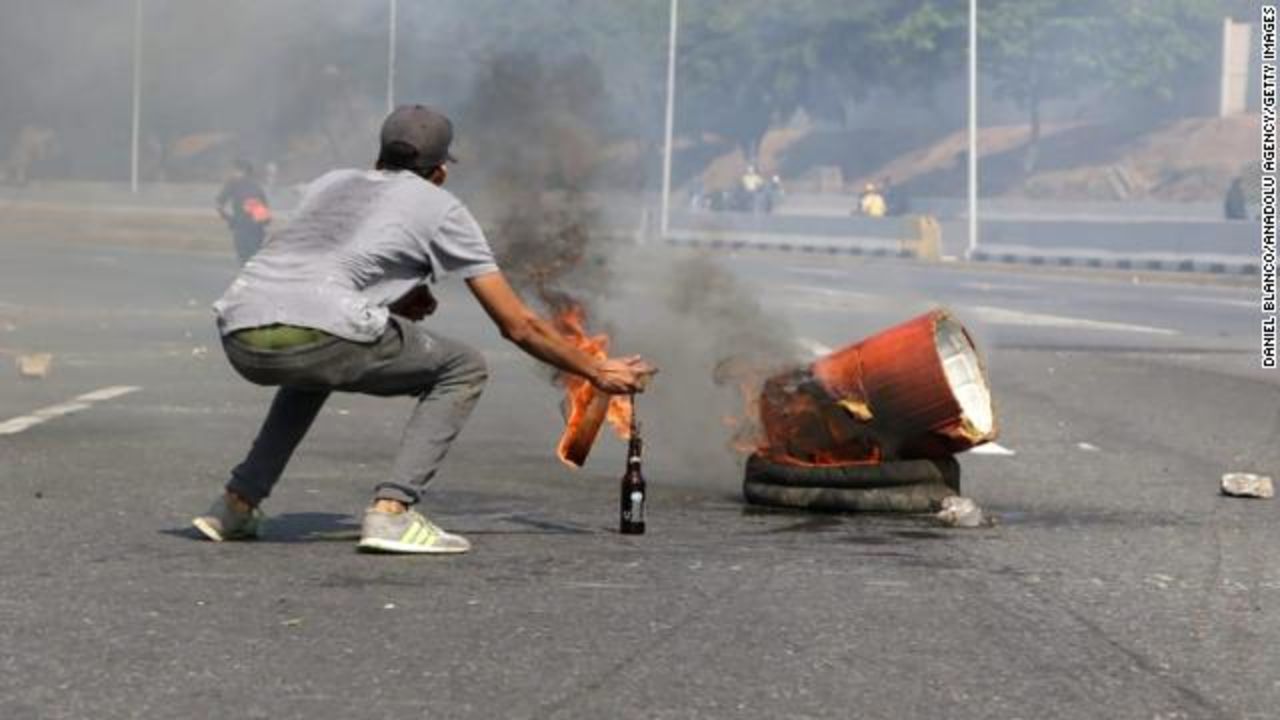 A pro-coup supporter throws a molotov cocktail near military base of La Carlota, in Caracas, Venezuela.