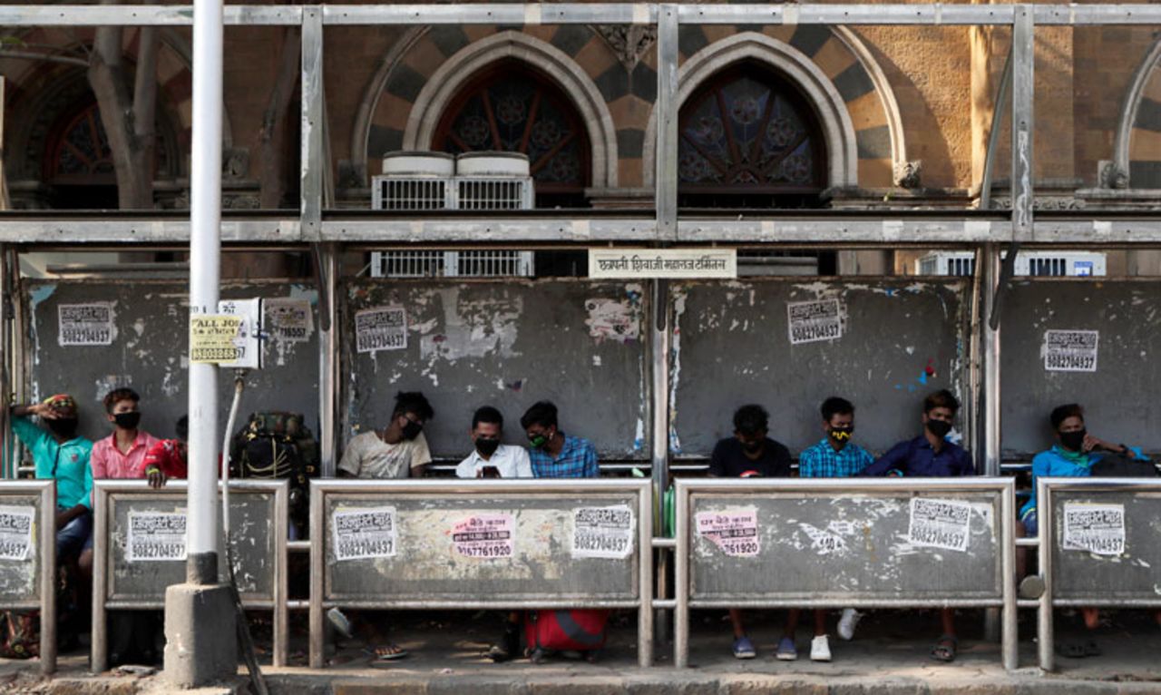 Commuters wearing protective face masks as a precaution against the new virus wait at a bus station in Mumbai, India, Wednesday, March 18.