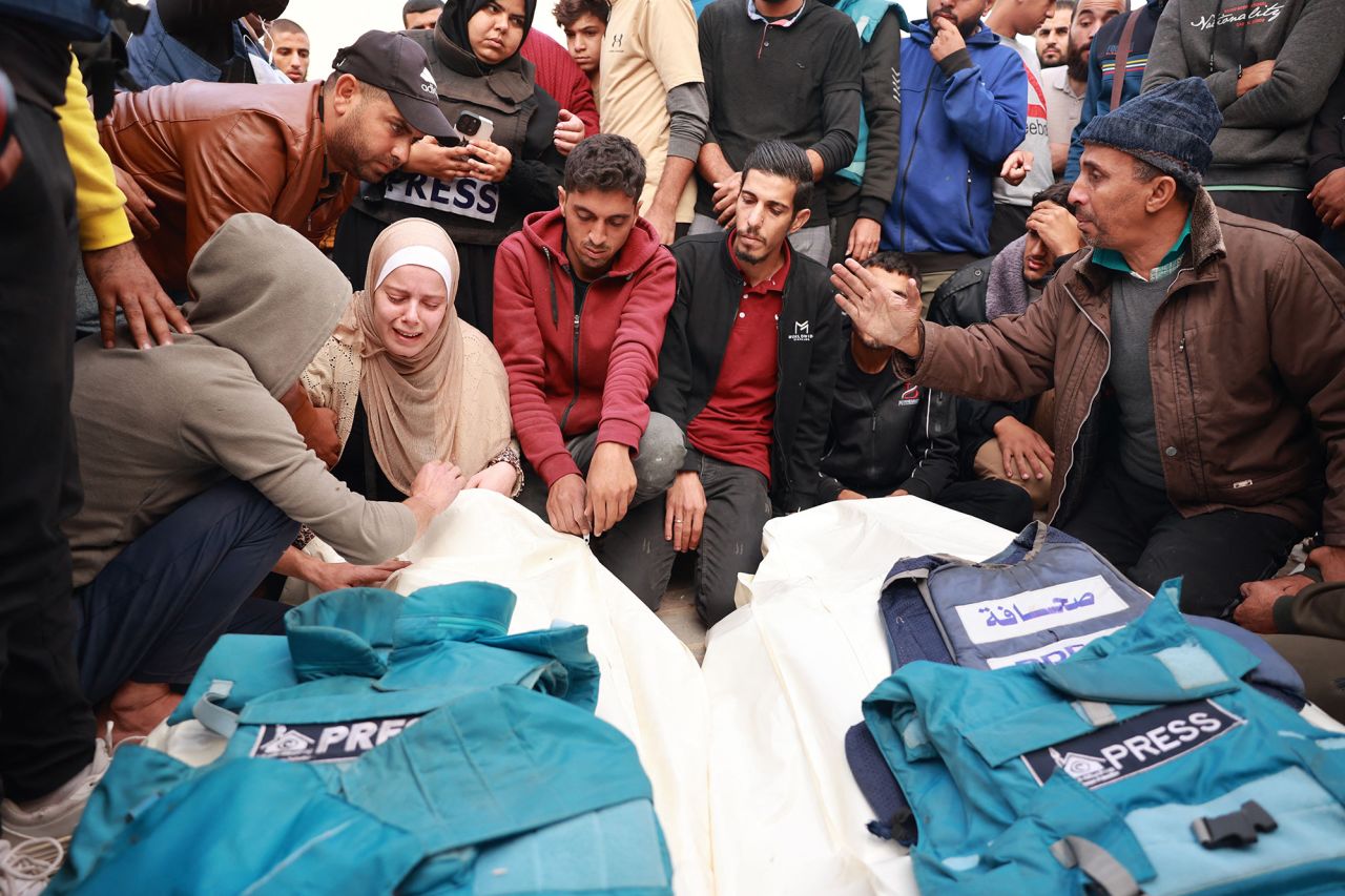 Relatives and colleagues of two Palestinian journalists Hasouna Slim and Sari Mansoor, killed in an Israeli strike, mourn over their bodies during their funeral in Deir al-Balah, Gaza, on November 19.