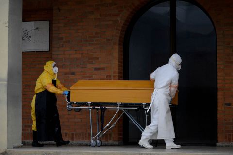 Funeral workers prepare to cremate a coronavirus victim at Serafin cemetary near Bogota, Colombia, on July 4.