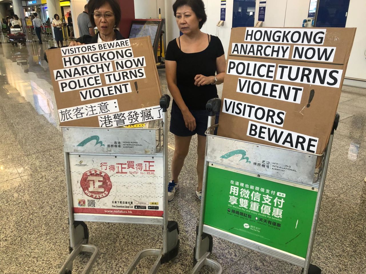 Protesters hoist signs onto luggage carts at Hong Kong's airport.