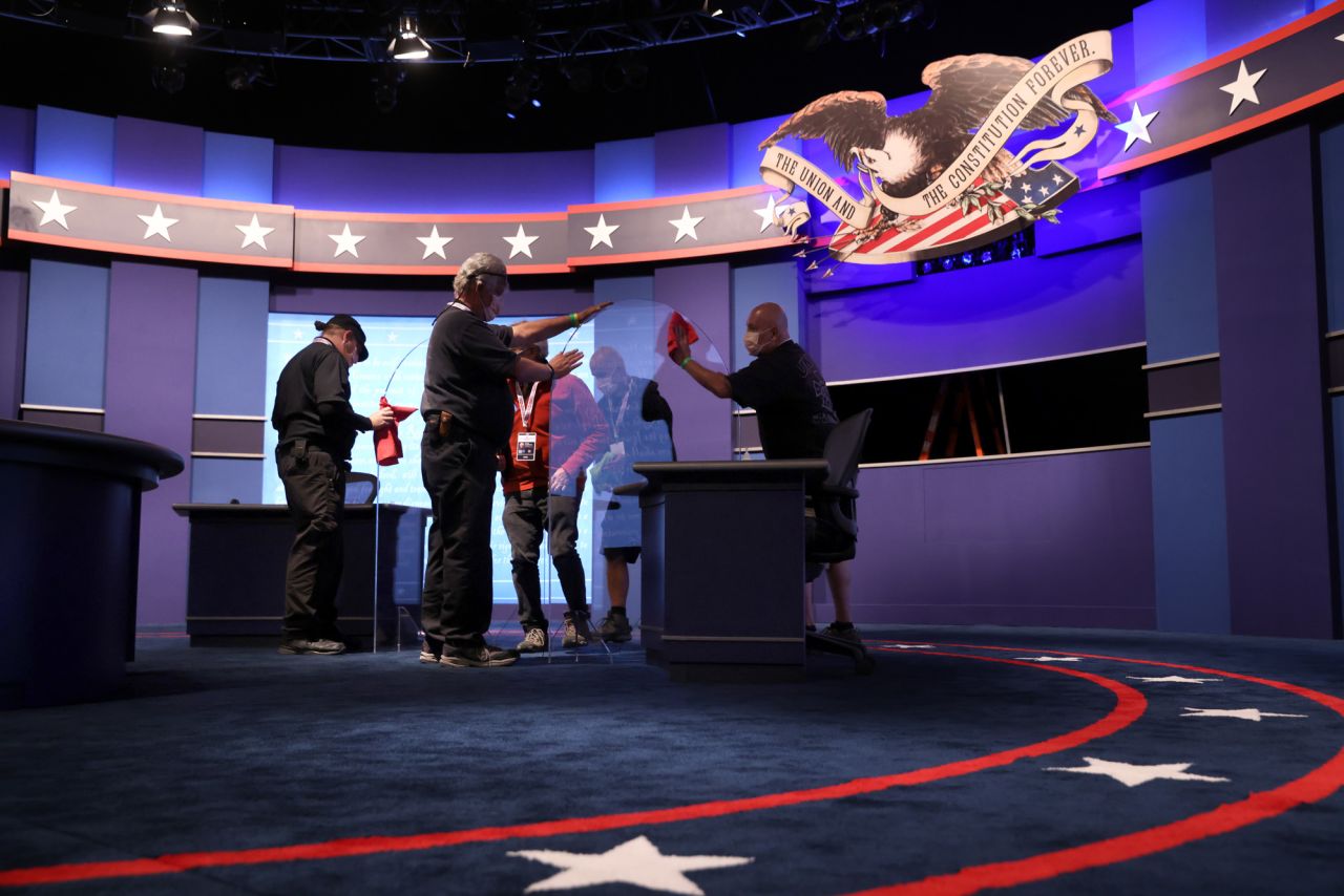 Workers clean newly installed transparent barriers on the stage ahead of the vice presidential debate in Kingsbury Hall at the University of Utah on October 6 in Salt Lake City, Utah. 