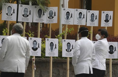 Doctors look at photos of their colleagues who died of COVID-19 after attending patients during the new coronavirus pandemic in Lima, Peru, Friday, on May 29. 