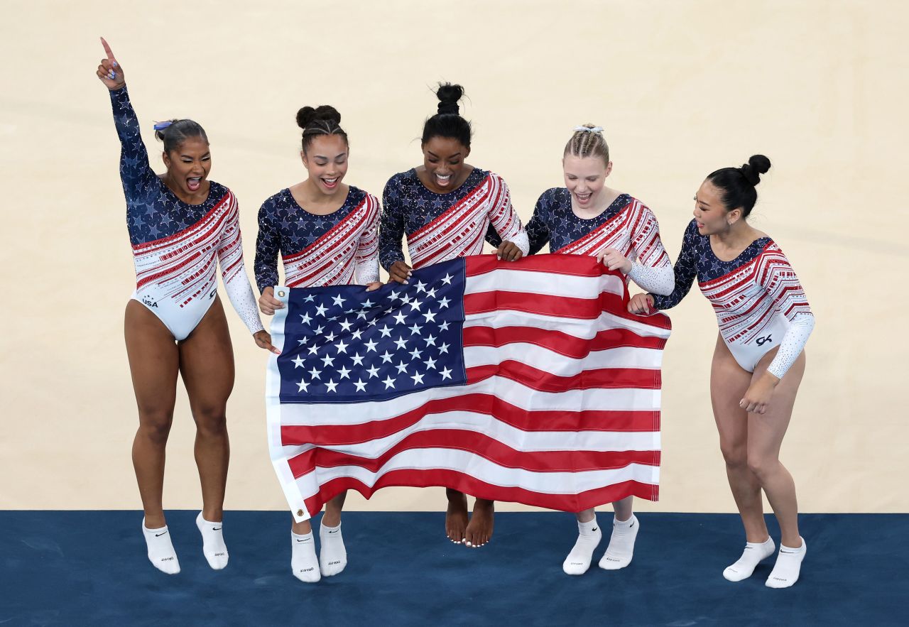 Left to right: Jordan Chiles, Hezly Rivera, Simone Biles, Jade Carey and Suni Lee celebrate during winning gold on Tuesday.