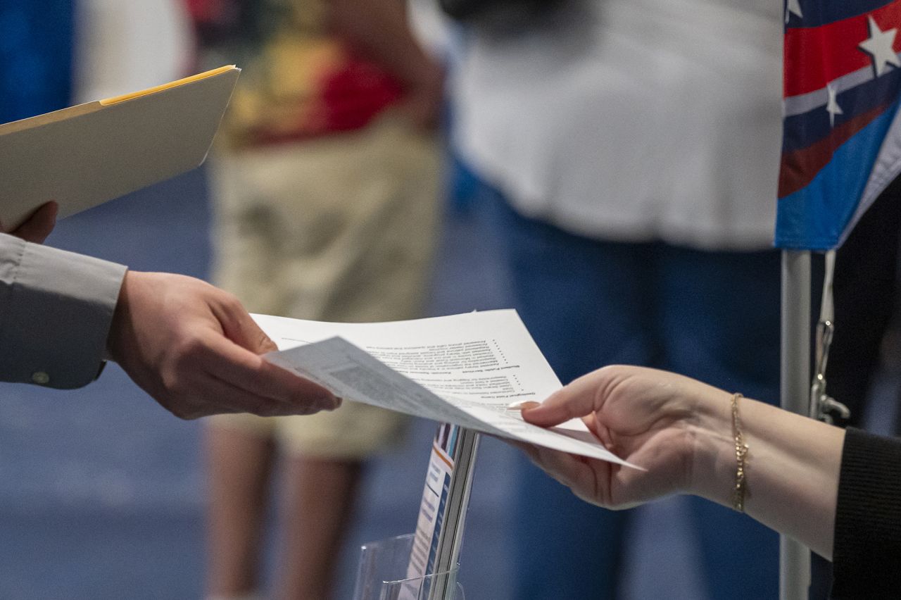 An attendee hands a recruiter a resume at a City Career Fair hiring event in Sacramento, California, on June 5.