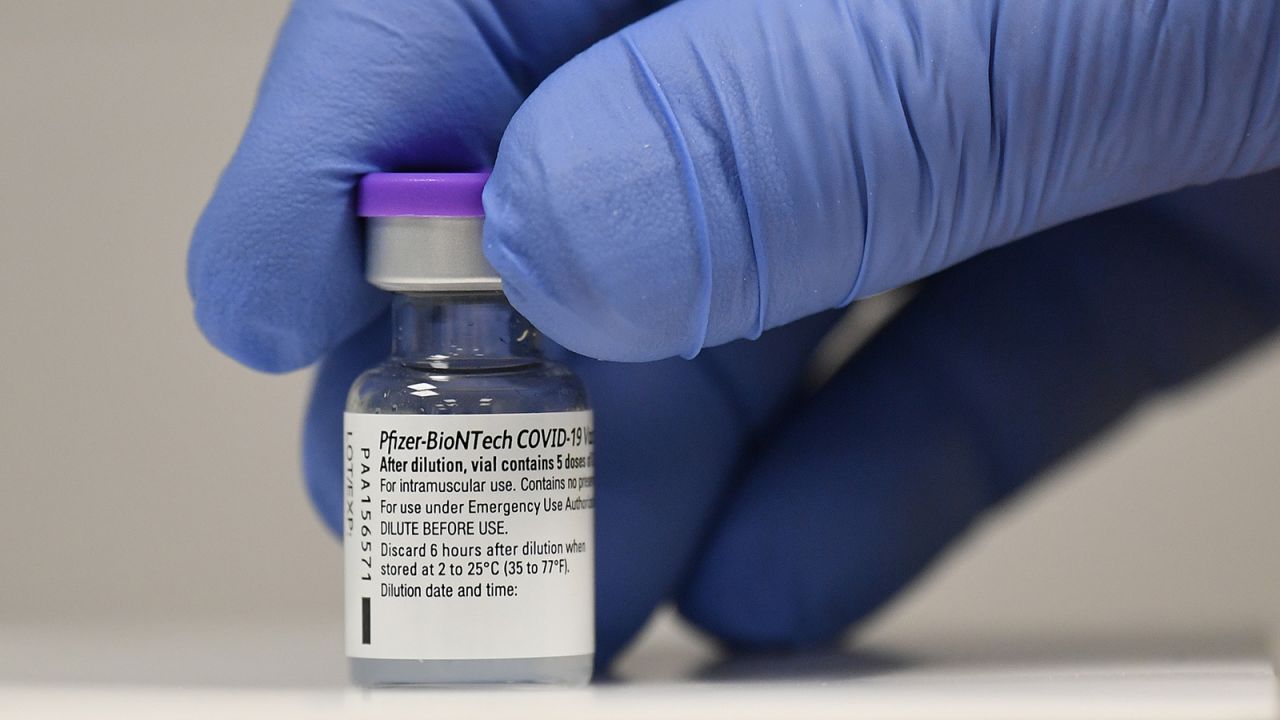 A member of staff poses with a vial of Pfizer-BioNTech Covid-19 vaccine at a vaccination health center in Cardiff, United Kingdom, on December 8, 2020.