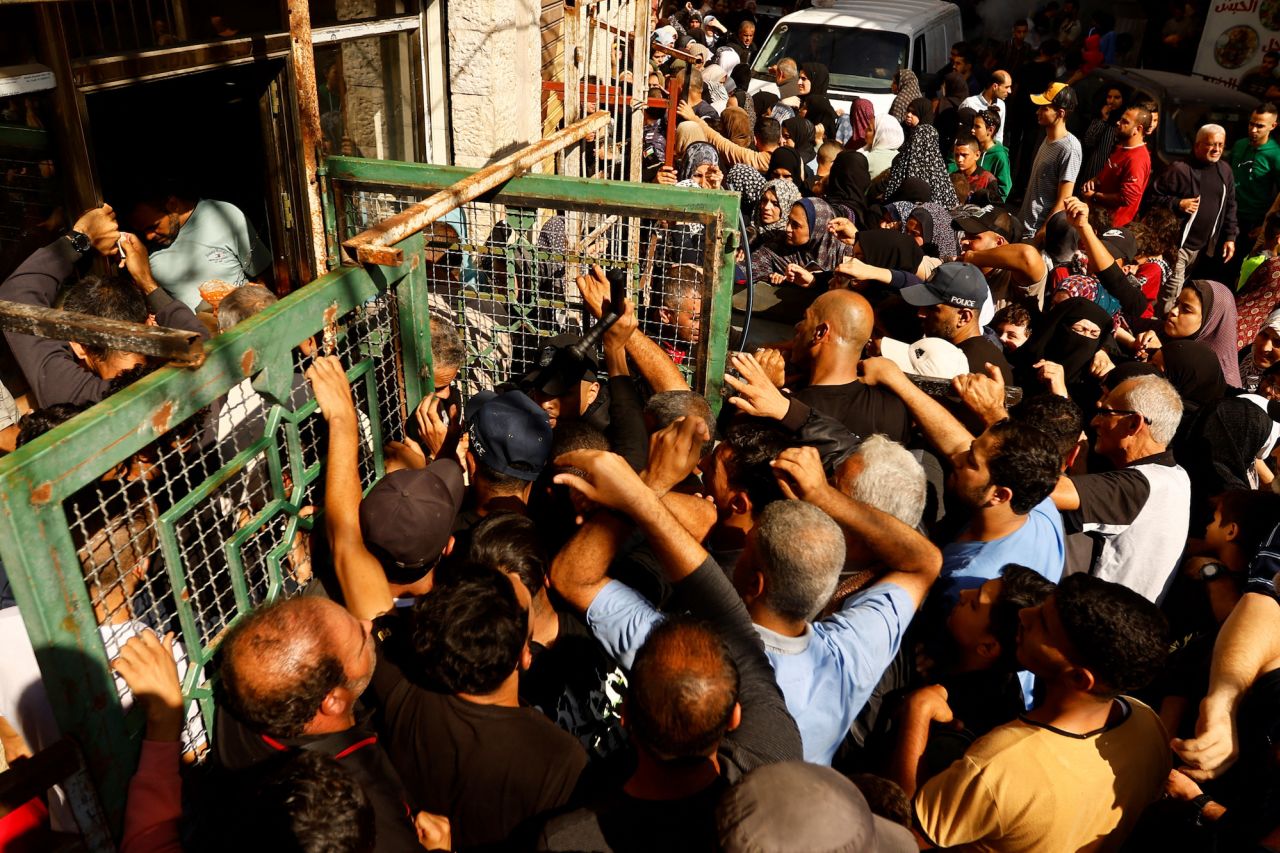 Palestinians queue as they wait to buy bread from a bakery amid food shortages in Khan Younis on November 17.