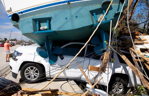 A boat sits on top of a vehicle at Fort Myers Beach on Thursday.