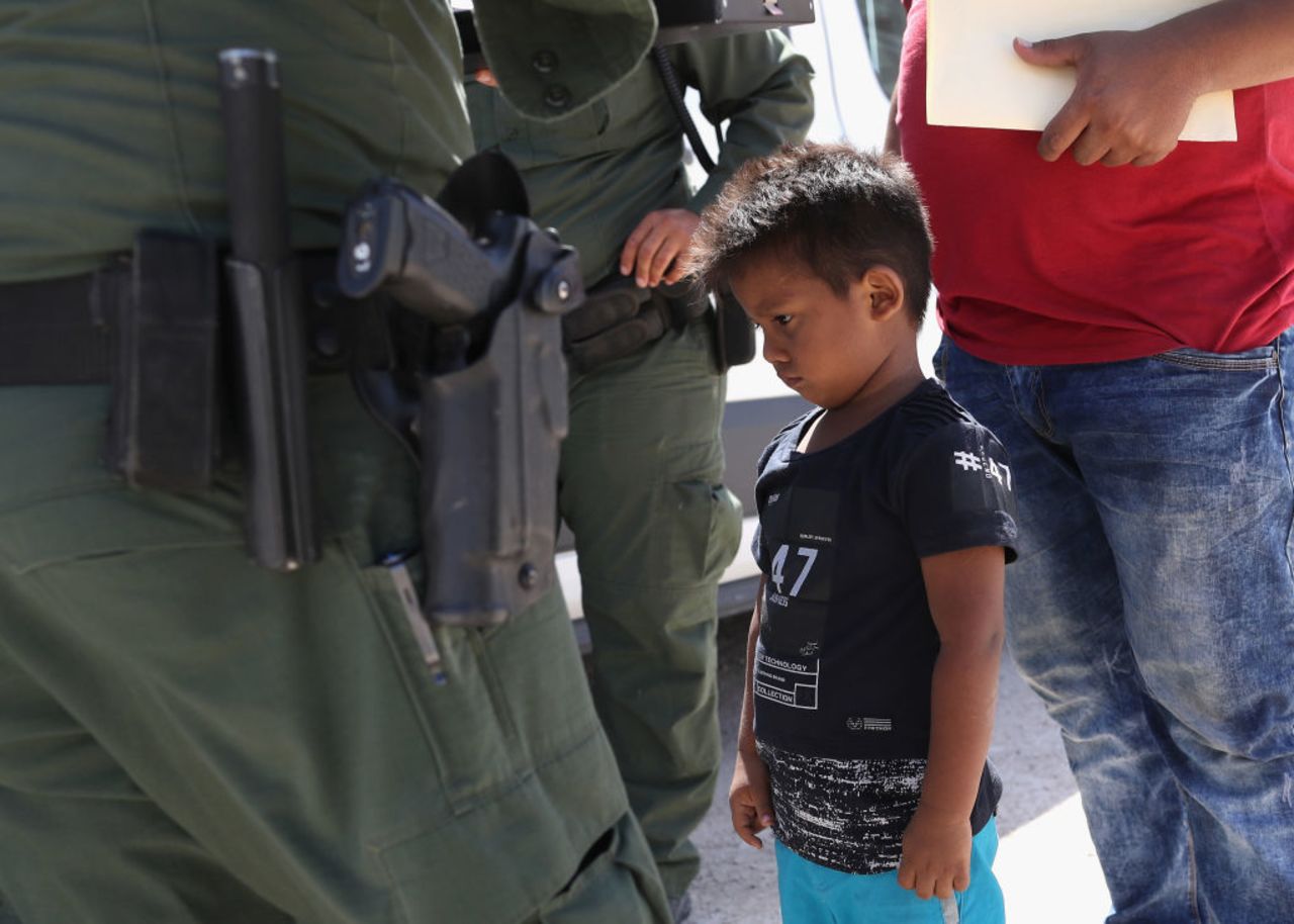 A boy and father from Honduras are taken into custody by US Border Patrol agents near the US-Mexico Border on June 12, 2018 near Mission, Texas. The asylum seekers were then sent to a US Customs and Border Protection (CBP) processing center for possible separation. 