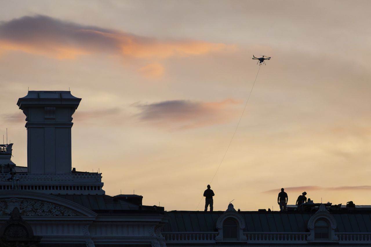 Secret Service agents work with a drone on top of the Executive Office Building during Independence Day celebrations.