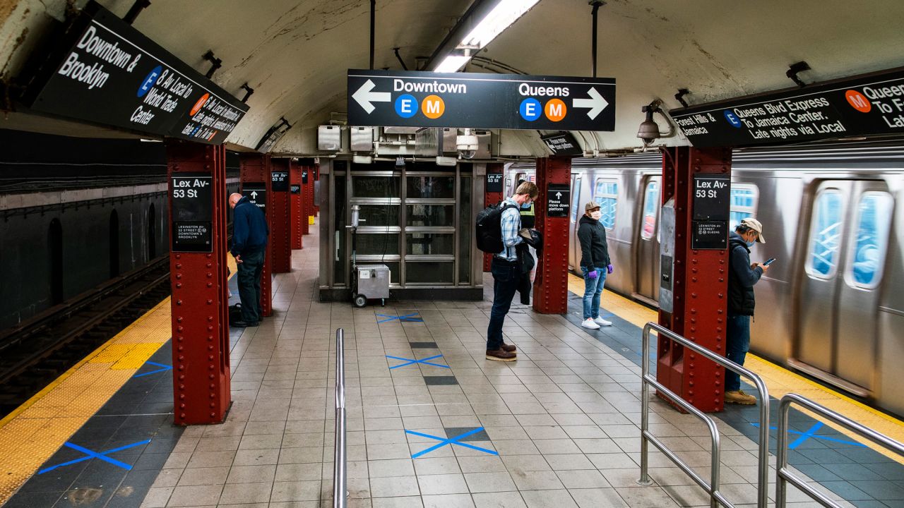 People wait by marked spots at a subway station on May 12 in New York City. 