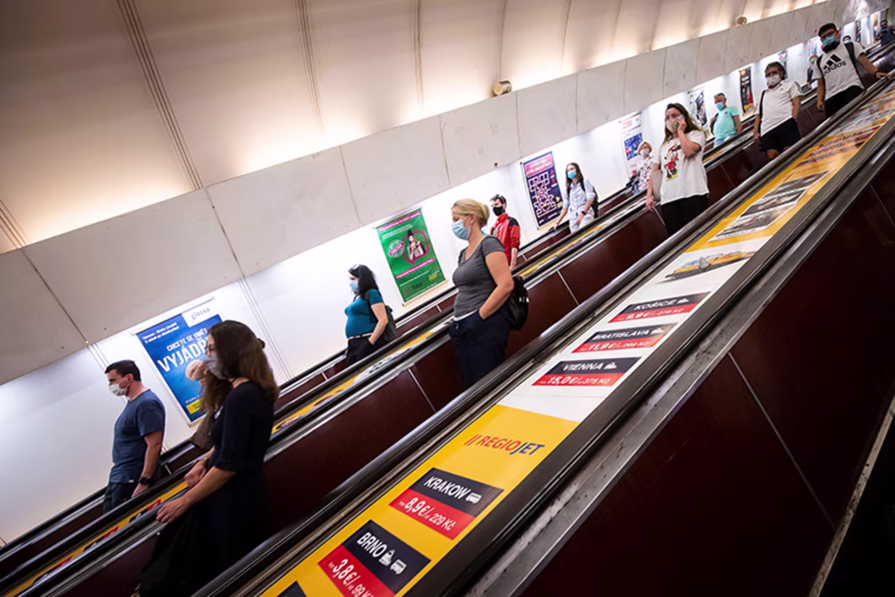 People wearing face masks stand on an escalator in a subway station on September 16, 2020, in Prague, Czech Republic. 