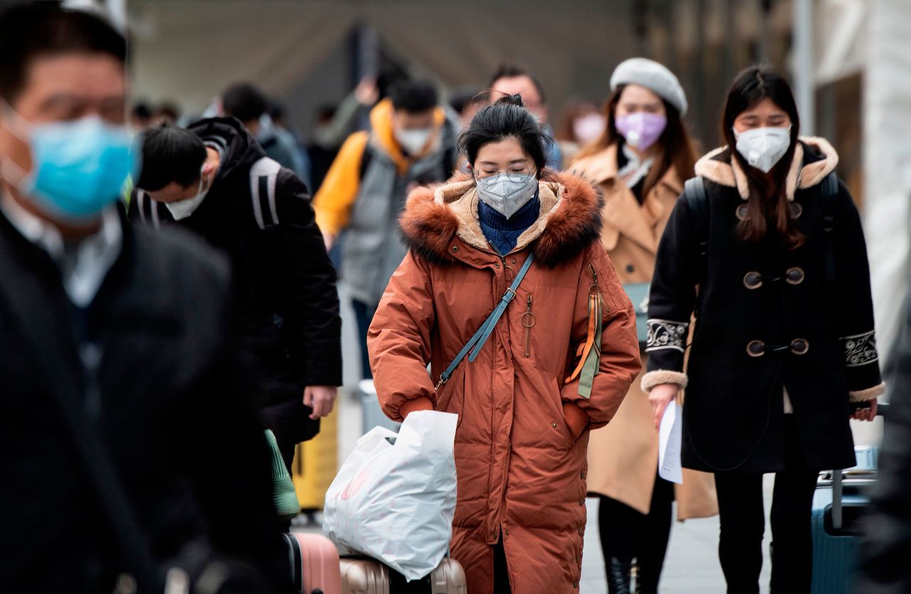 People wear protective face masks as they enter a railway station in Shanghai on Monday.