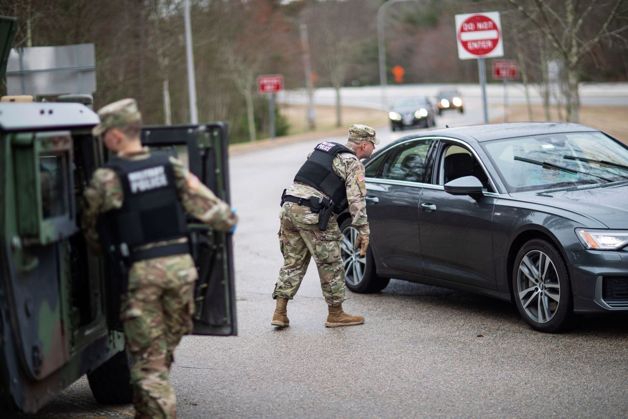 A member of the Rhode Island National Guard Military Police directs a motorist with New York license plates at a checkpoint on the border of Connecticut and Hope Valley, Rhode Island on March 28. New Yorkers had to pull over and provide contact information and were told to self-quarantine for two weeks.